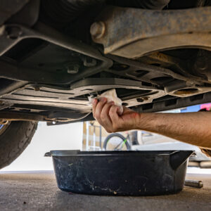 Mechanic draining oil from under a truck during inspection for 2023 Sierra metal shavings in oil issue.