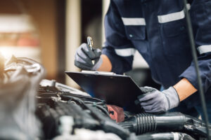 Mechanic inspects engine and documents repairs while diagnosing common Jeep Wagoneer problems during service.